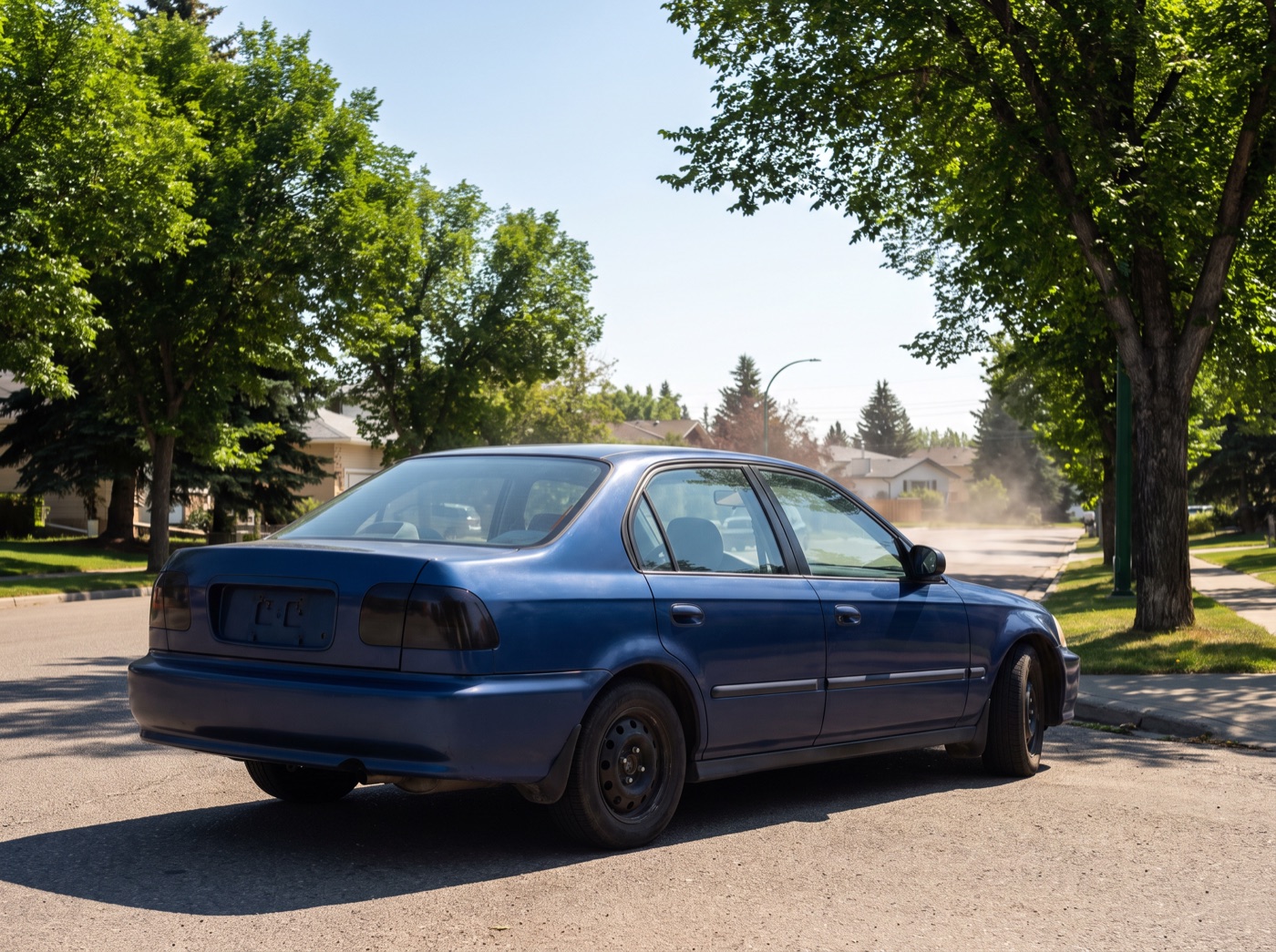 Sedan parked on a hot, sunny Calgary residential street in summer