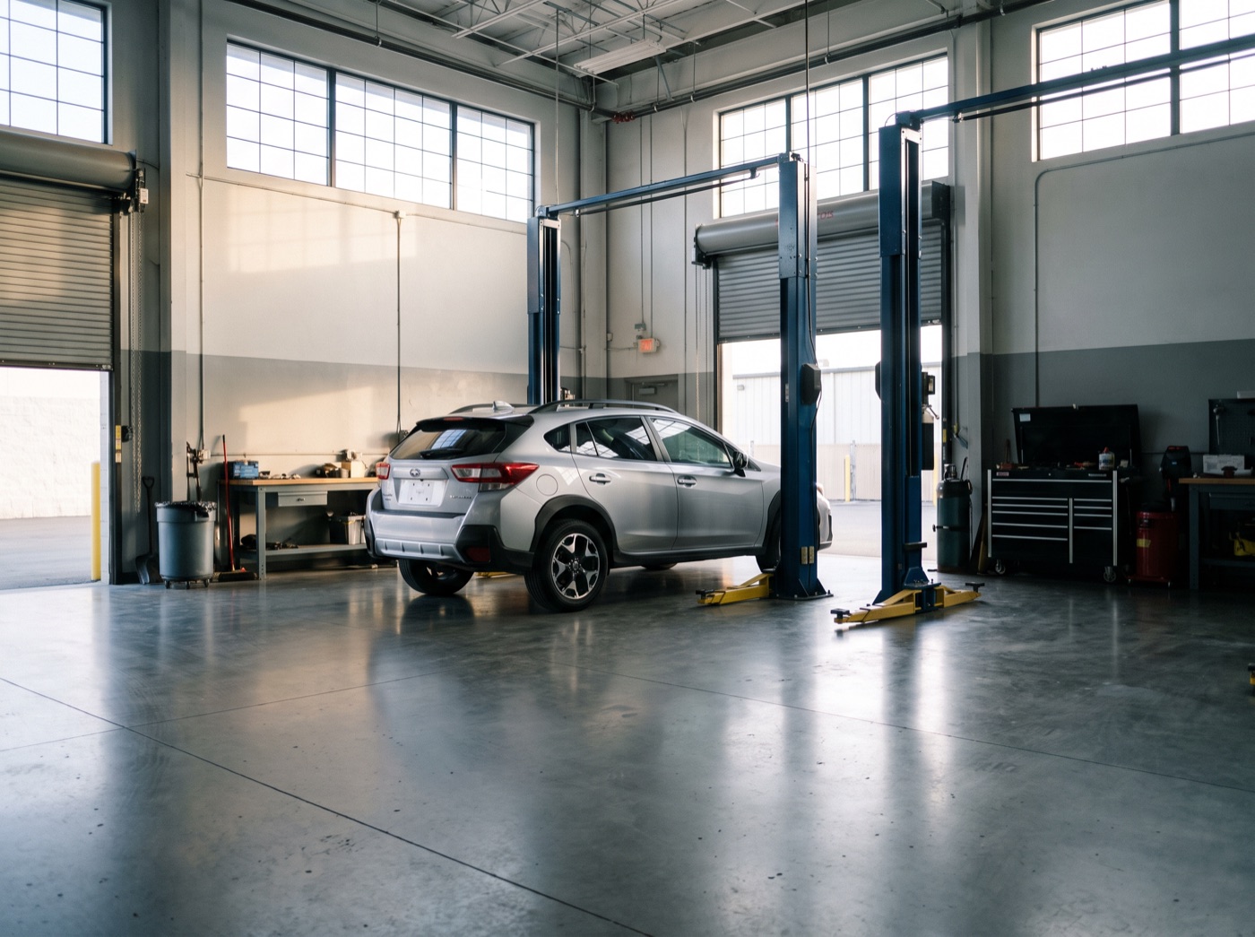 Crossover parked between lift posts in a clean repair bay, ready for inspection