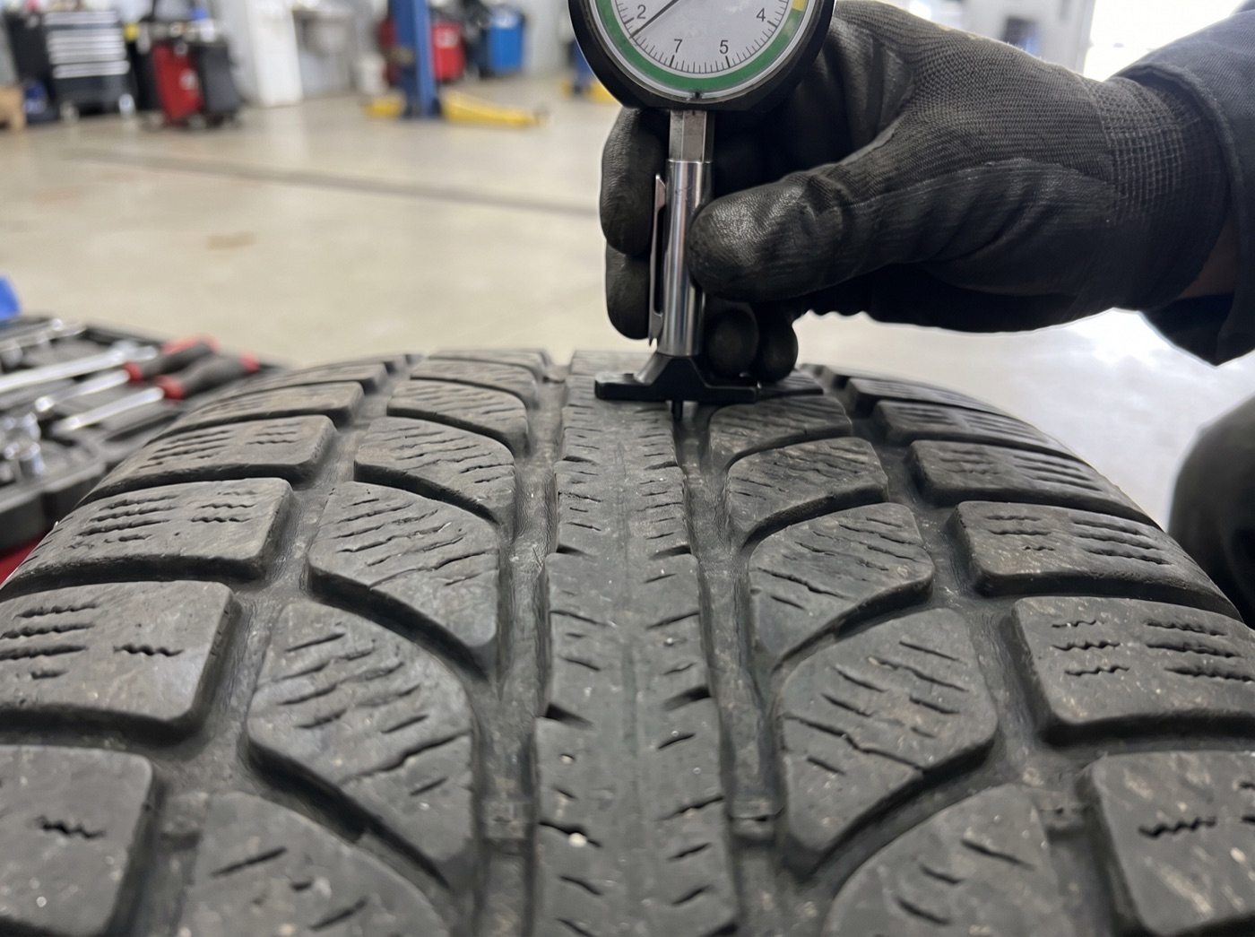 Tread depth gauge in a worn winter tire groove